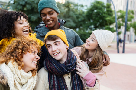 Young group of multiracial friends in winter clothes having fun together outsideの写真素材
