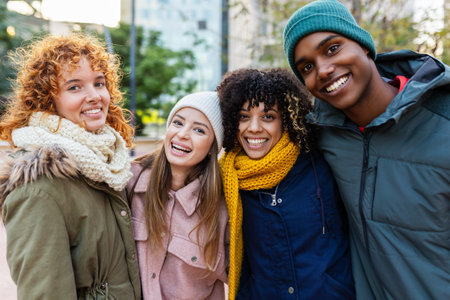 Group of diverse Gen Z friends smiling together outdoors in winterの写真素材