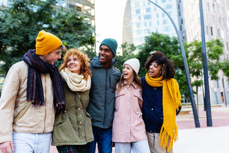 Young group of diverse people walking together on winter at city streetの写真素材