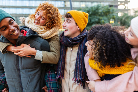 Young group of happy diverse friends laughing at city street on winter seasonの写真素材