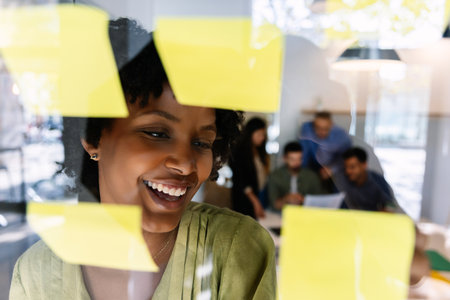 Businesswoman writing notes on glass wall during planningの写真素材