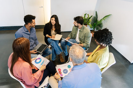 Business group sitting in circle discussing planning ideasの写真素材