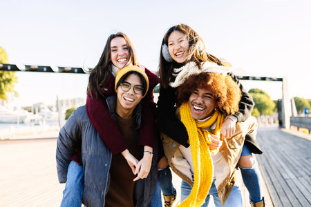 Portrait of diverse young group of friends laughing together outdoor on winterの写真素材