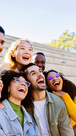 Happy multi-ethnic students laughing together outdoors in the city