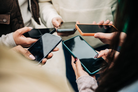 Close view of young people hands holding mobile phones