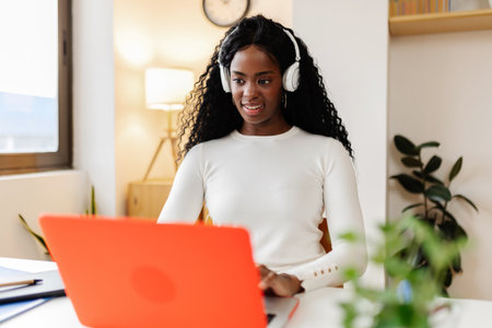 Young student African American woman working on laptop at home