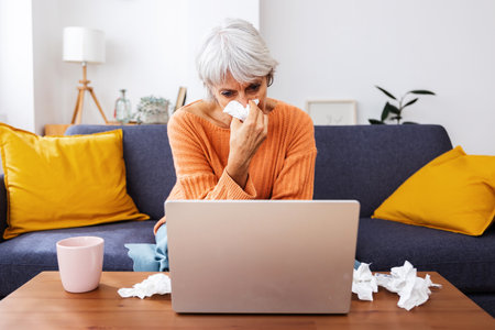 Senior sick woman having a video call with doctor from homeの写真素材