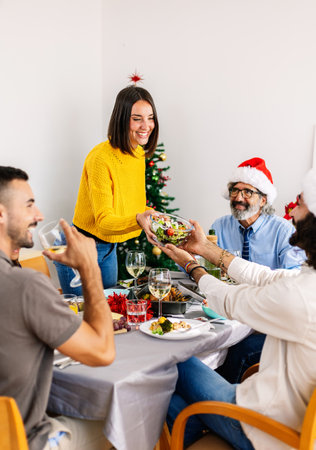Woman serving christmas dinner to friends at homeの写真素材