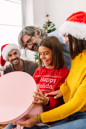 Happy family opening christmas gift at homeの写真素材