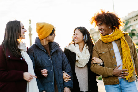 Happy friends in warm clothes walking and having fun together in winterの写真素材