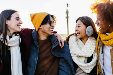 Diverse group of young friends having fun together outdoors on winterの写真素材