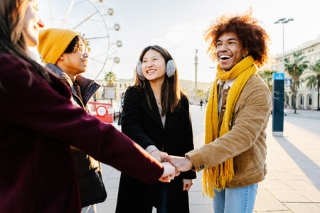 Multiracial happy friends with hands in stack at city streetの写真素材