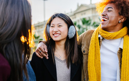 Diverse group of young friends having fun together outdoors on winterの写真素材