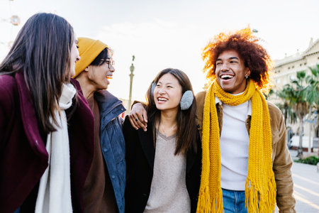 Diverse group of young friends having fun together outdoors on winterの写真素材