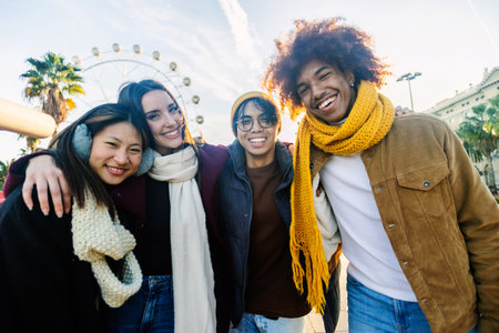 Portrait of diverse young group of friends laughing together outdoor on winterの写真素材
