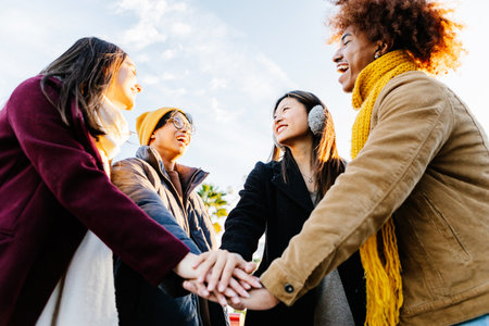 Multiracial happy friends with hands in stack at city streetの写真素材