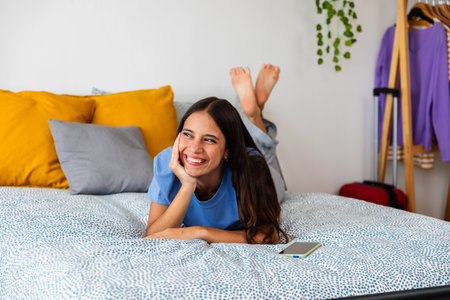 Portrait of teenage student girl looking away daydreaming in bedroomの写真素材