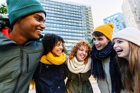Young diverse friends having fun outdoors during a cold winter dayの写真素材