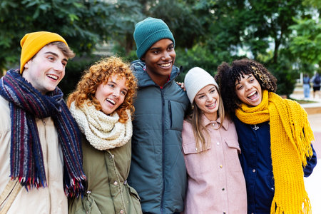 Young group of friends on winter clothes having fun together at city street