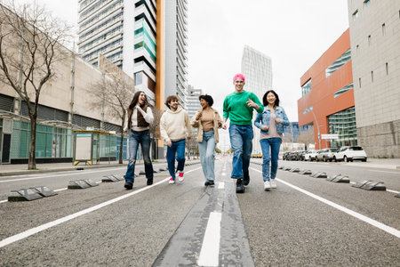 Group of diverse young friends running together on street