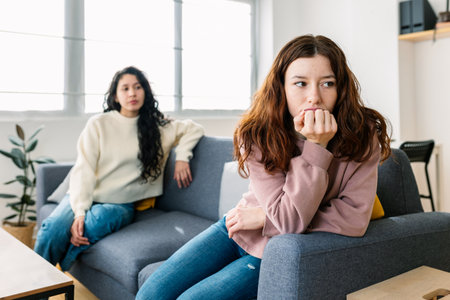 Two friends in tension sitting on a sofa