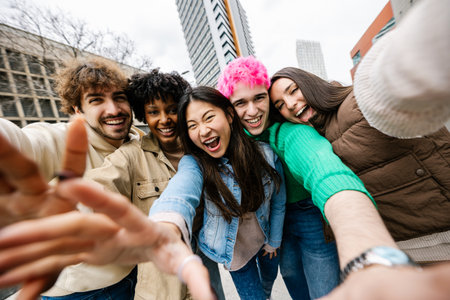 Multiracial group of young friends smiling while taking selfieの写真素材