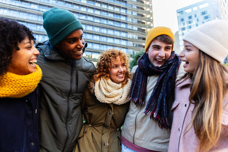Young diverse happy friends enjoying winter day together in city streetsの写真素材