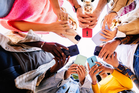 Young group of student people using smart phones together outside