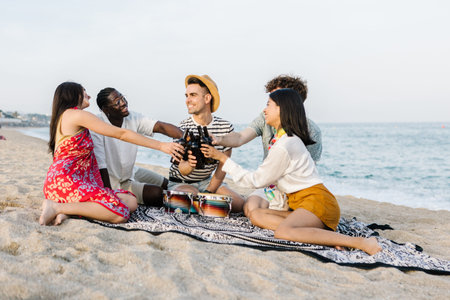 Diverse friends celebrating on a beach picnicの写真素材
