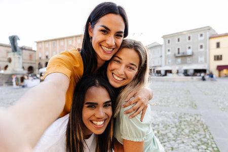 Three multiracial young women taking selfie portrait during summer vacation