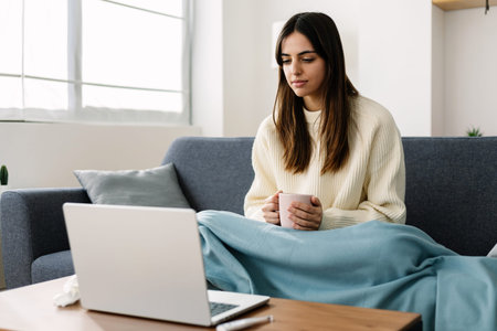 Young woman having an online video call with doctor from homeの写真素材