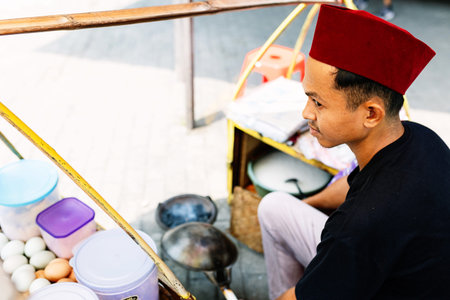 Young indonesian street vendor cooking local food in traditional market