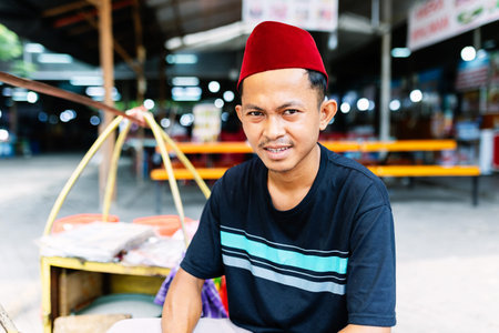 Portrait of young indonesian street vendor selling local food at marketの写真素材
