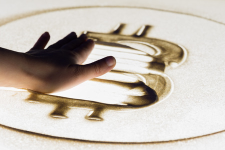 Erased bitcoin sign, sand painting on lightboxの写真素材