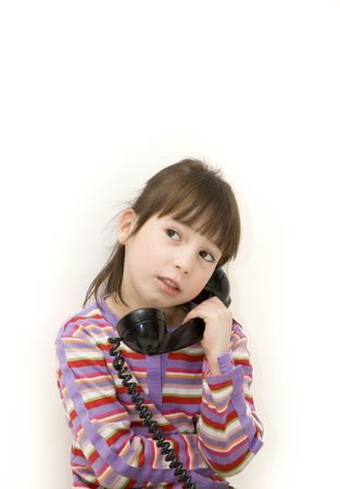 little girl on the antique phone over a white backgroundの写真素材