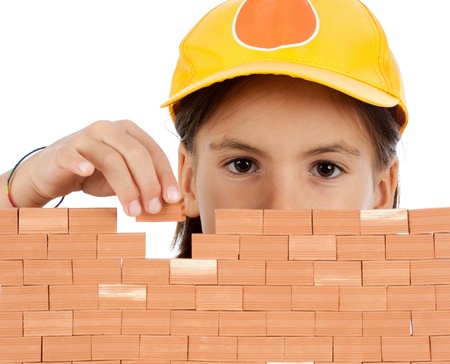 little girl building a wall isolates on white background の写真素材