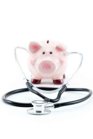 piggy bank with stethoscope isolated on white - selective focusの写真素材