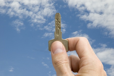 holding a key with sky backgroundの写真素材