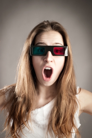 young woman watching a movie wearing 3d glassesの写真素材