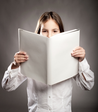 little girl reading a book with blank coverの写真素材
