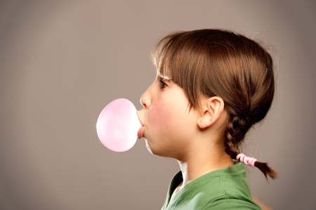 young girl making a bubble from a chewing gum の写真素材