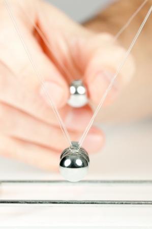 hand holding a pendulum ballの写真素材