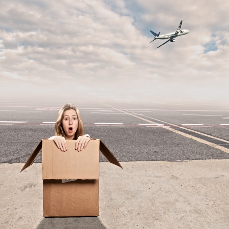young woman inside a box at airportの写真素材