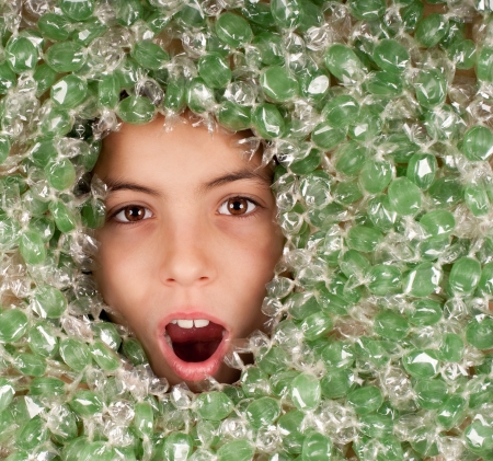 little girl buried on green candiesの写真素材