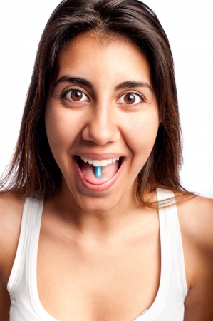 Young woman with a pill on her tongueの写真素材