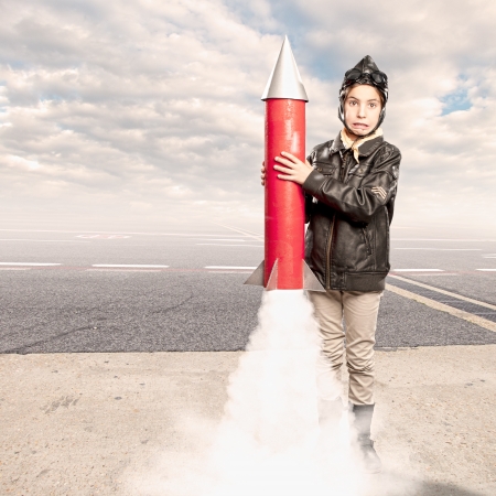 little aviator holding a rocket at the airportの写真素材