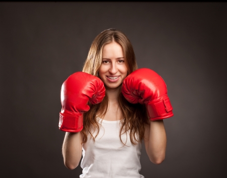 young woman wearing red boxing glovesの写真素材