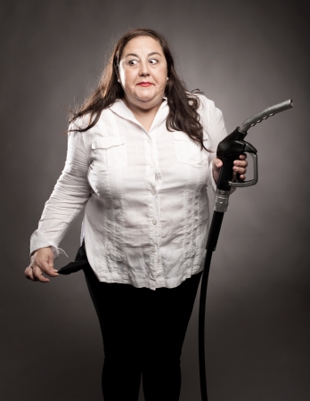 woman holding a fuel pump nozzleの写真素材