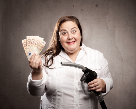 woman holding a fuel pump nozzleの写真素材