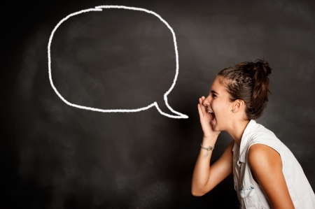 portrait of young girl screaming in front of chalkboard with speech bubble